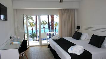 Habitación de hotel con cama, escritorio y vista al océano.