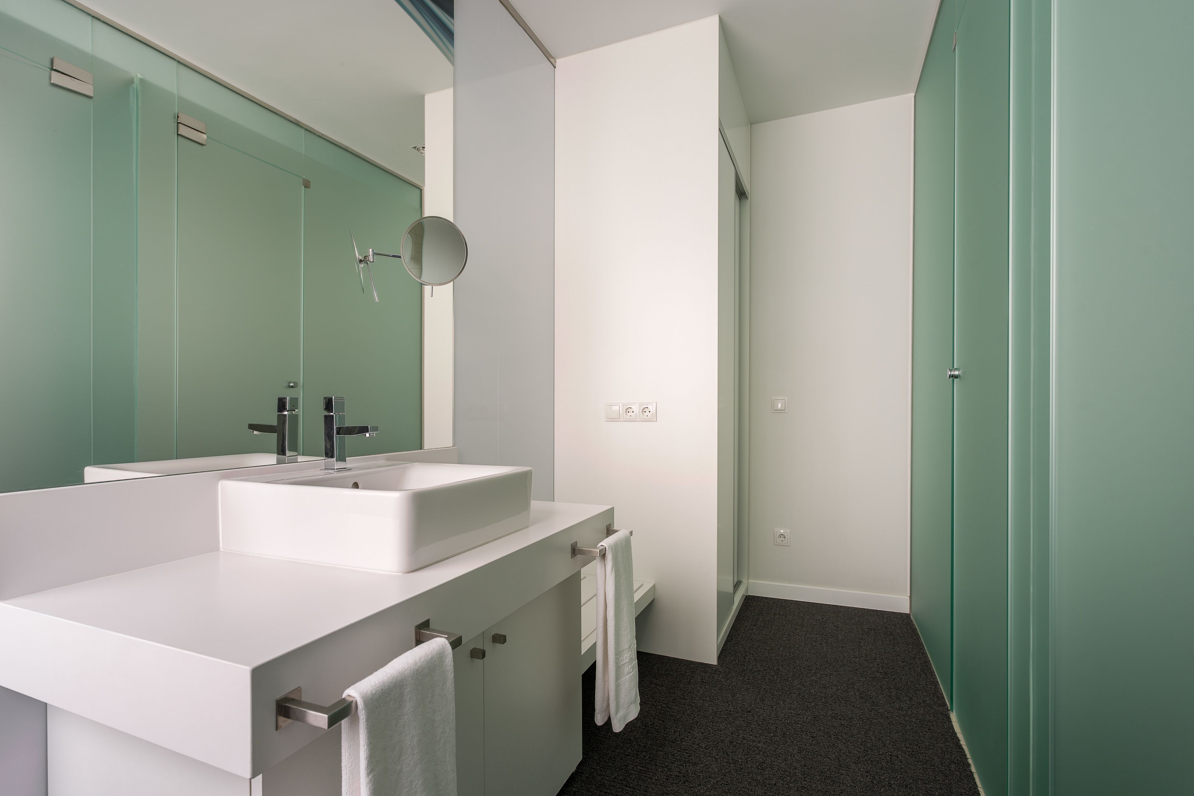 Een moderne badkamer met twee wasbakken, een spiegel en een handdoekrek.