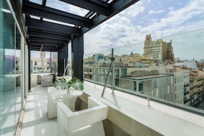 Enjoy the city views from this stylish balcony with a glass partition and comfortable seating.