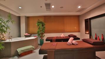 Relax in a serene spa room with a massage table, bench, and soothing green accents.