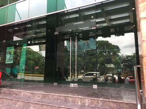 A hotel entrance with glass doors, a marble staircase, and a view of the street outside. - Crown Regency Hotel and Towers (Cebu City)
