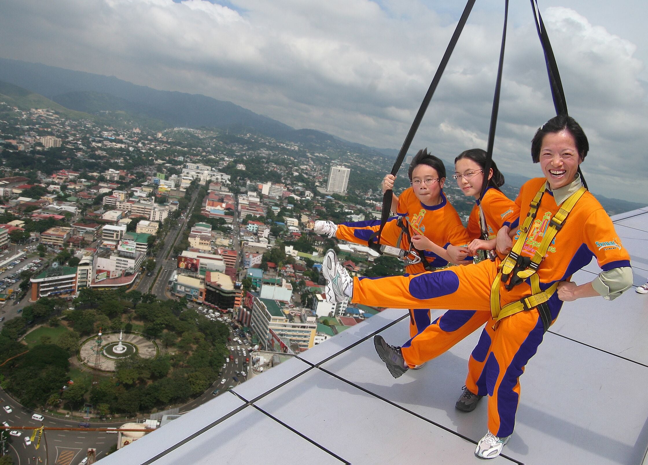 A group of people on a high platform with a cityscape view.