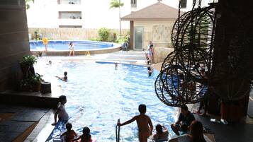 Una piscina techada, sillones reclinables de piscina