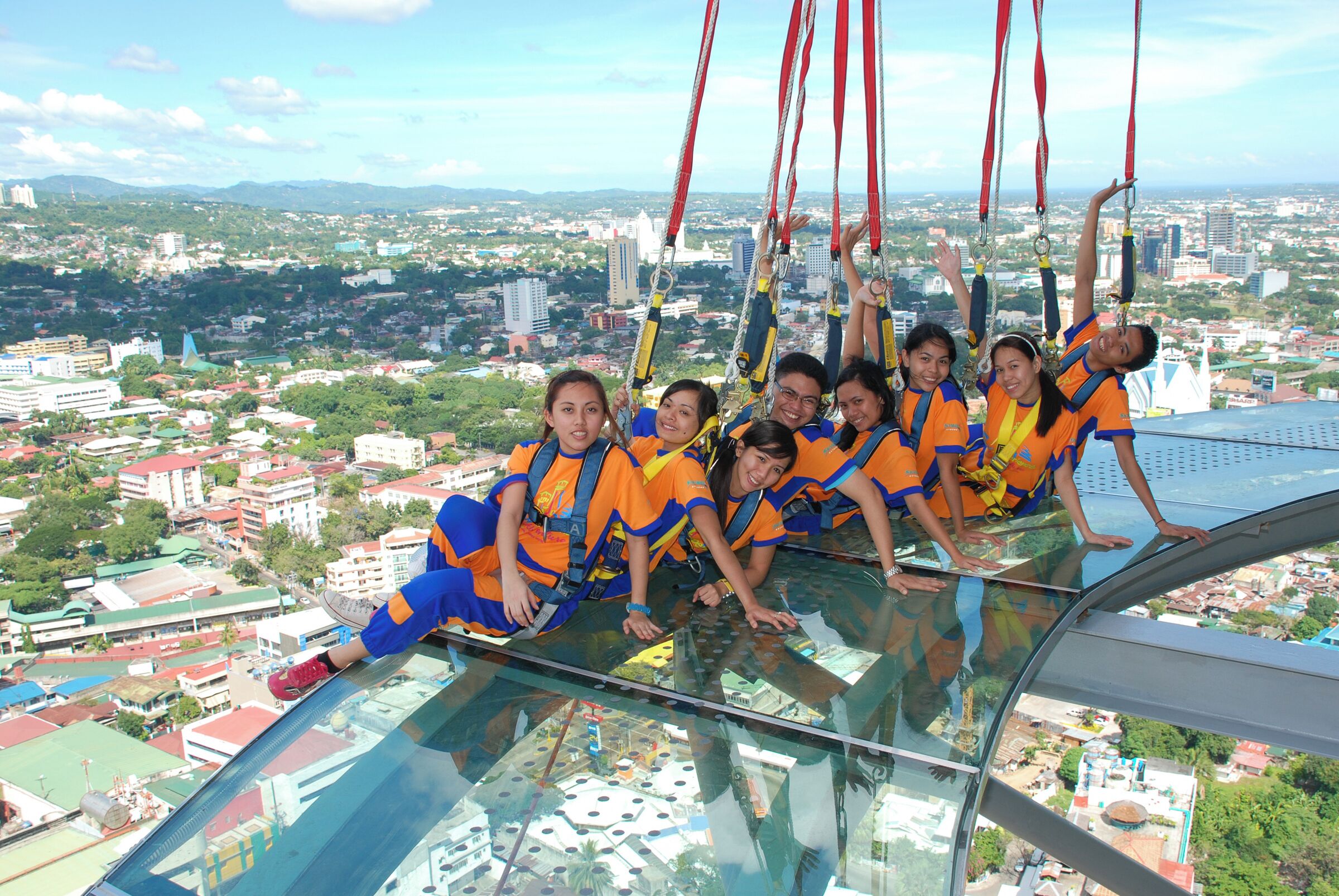 A group of people on a glass floor with a cityscape view.