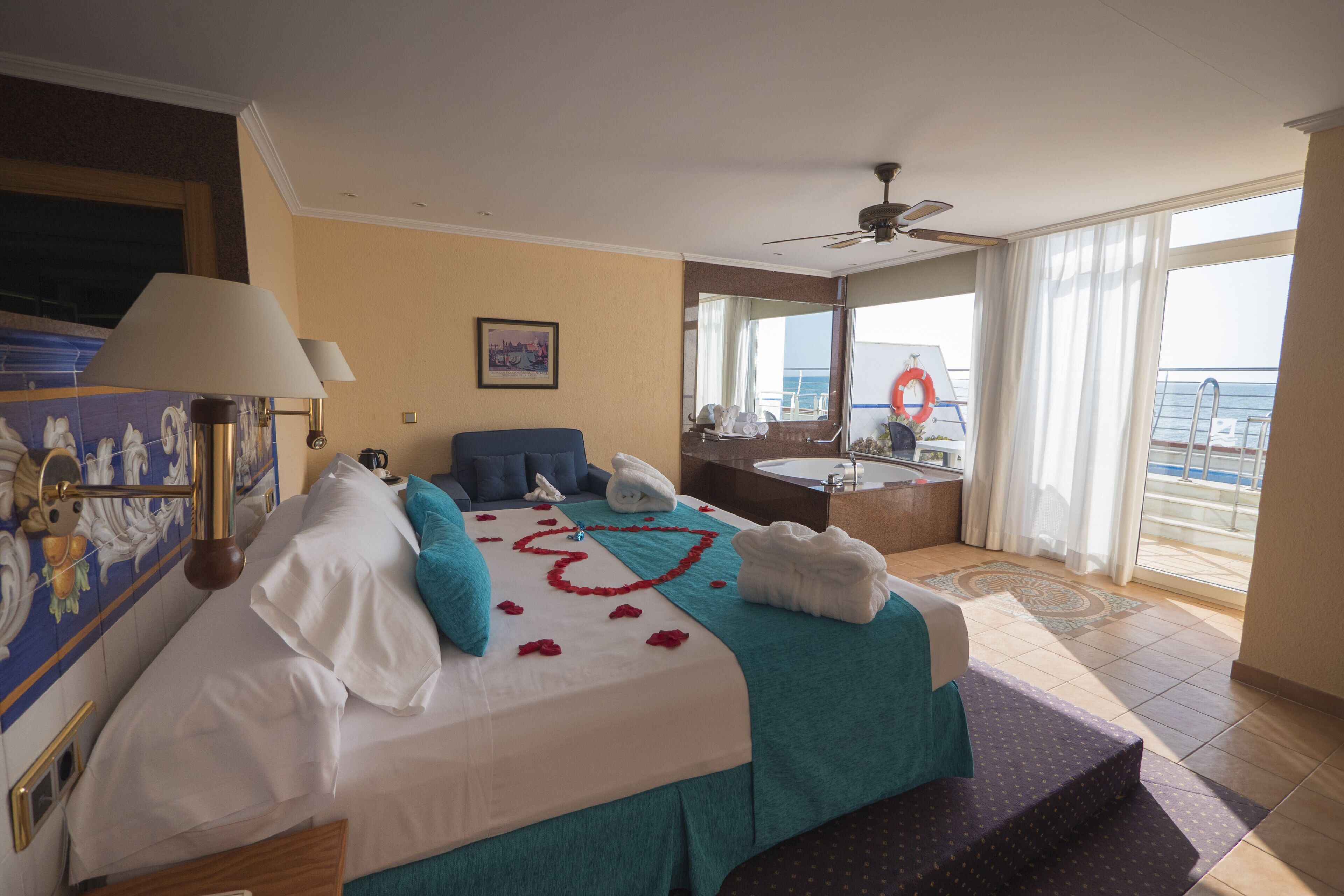 Una habitación de hotel con cama, baño y vista al mar.