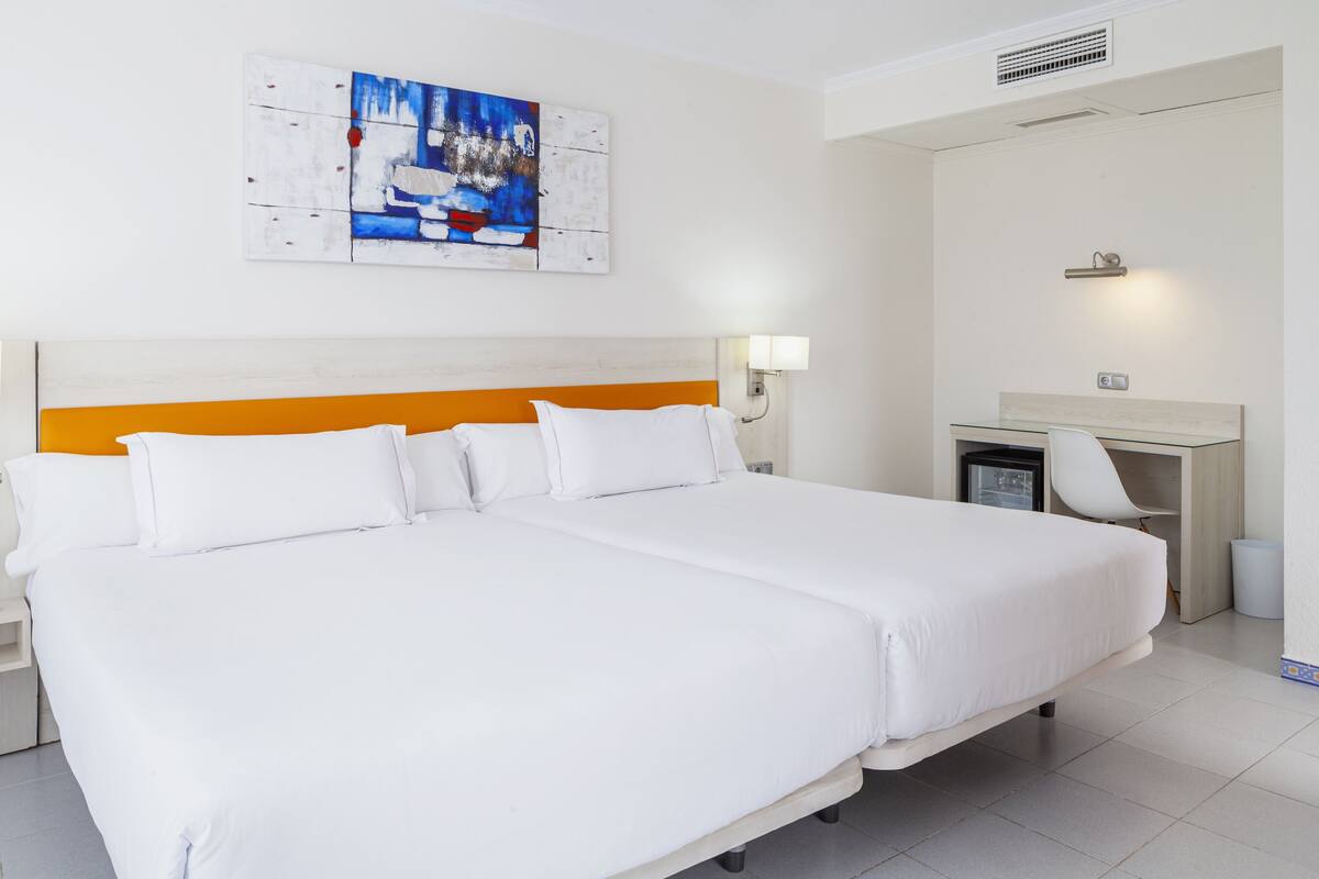 Une chambre d’hôtel avec un grand lit, un bureau et une chaise.