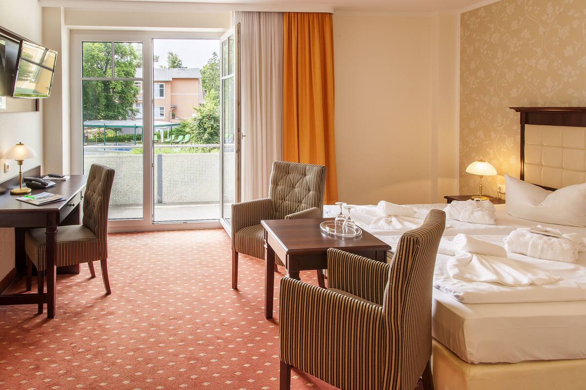 Una habitación de hotel con cama, escritorio, silla y mesa de comedor.