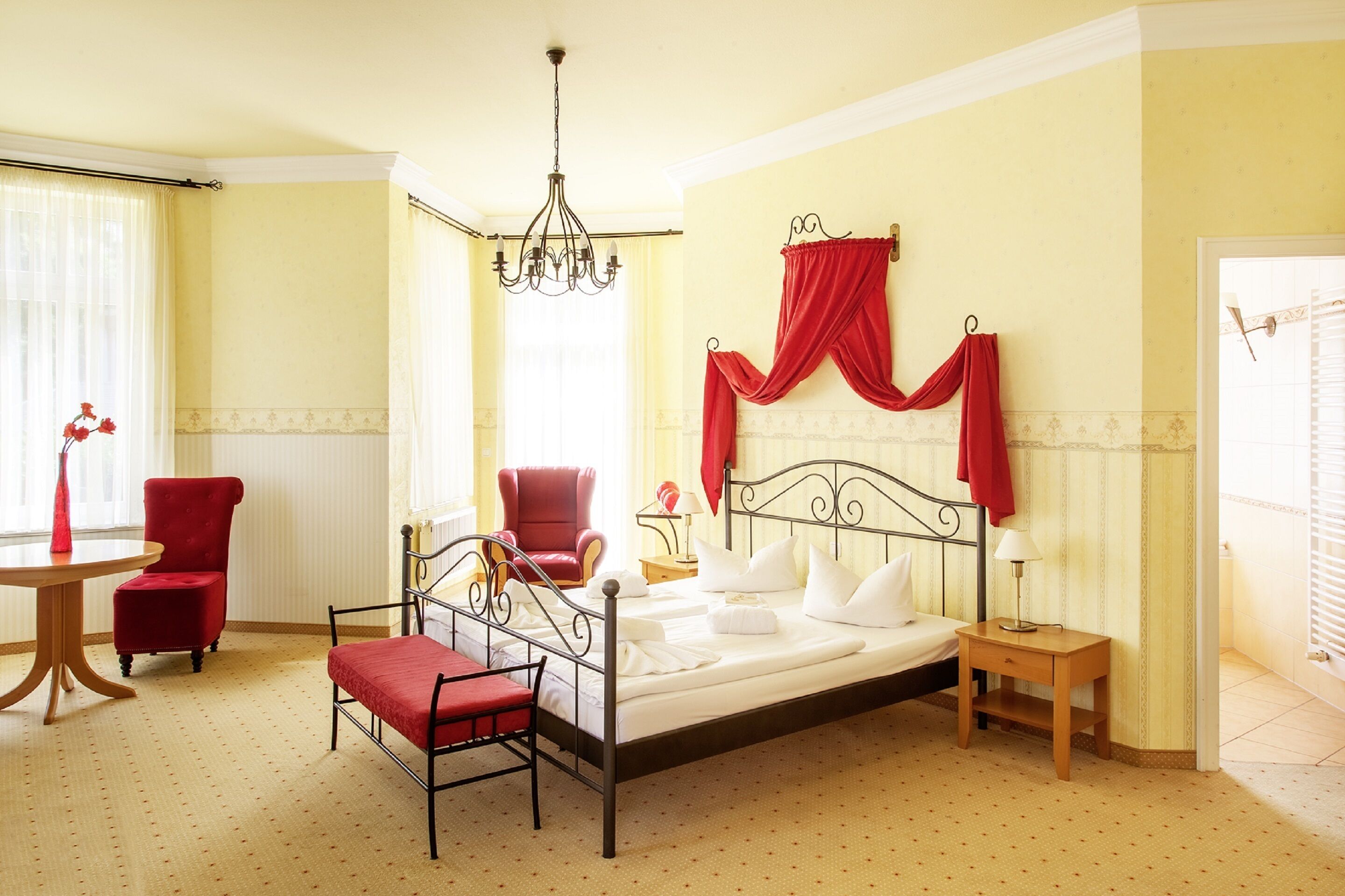 Une chambre à coucher avec un lit, une chaise, une table et un lustre.
