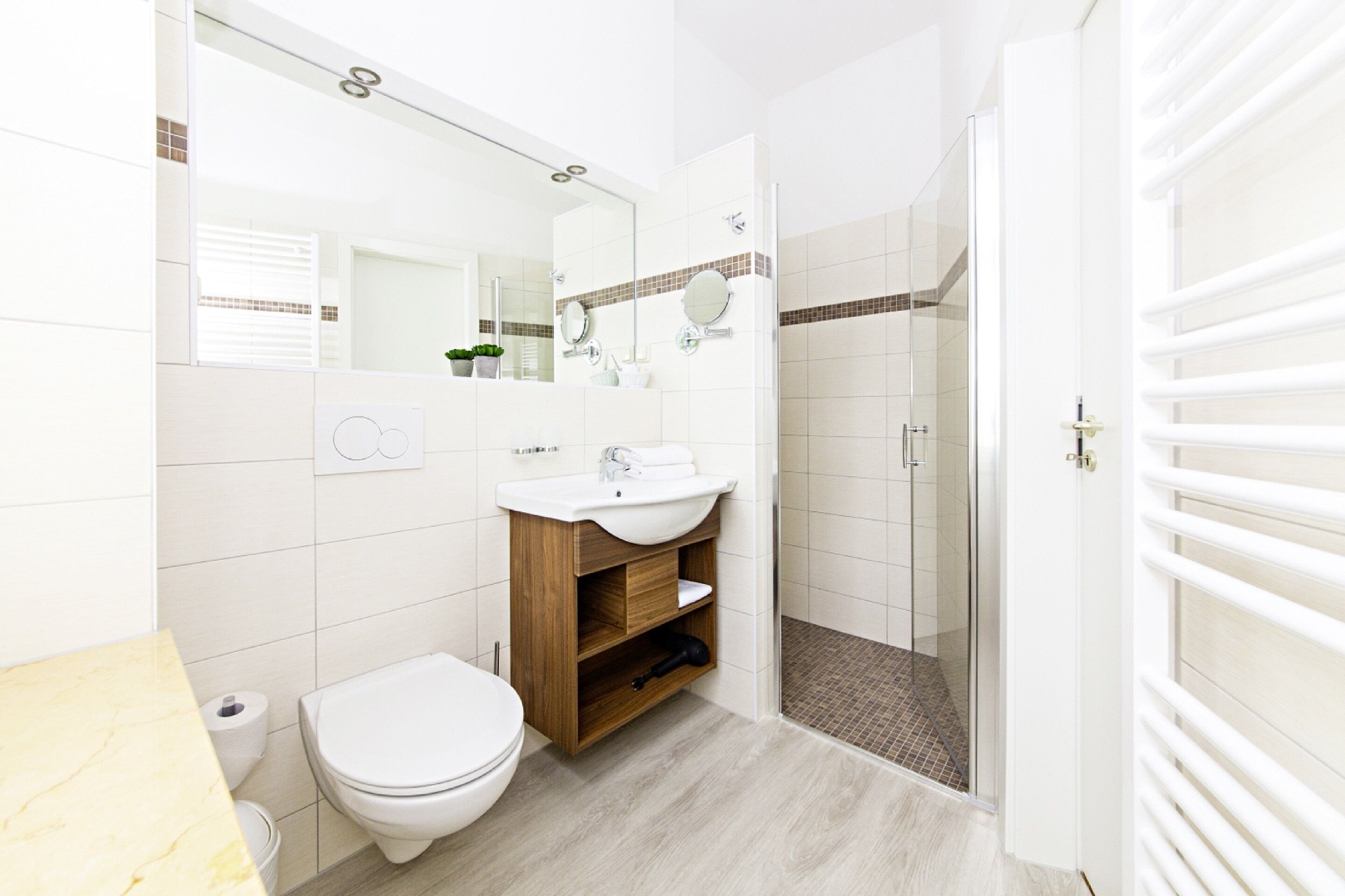 A modern bathroom with a toilet, sink, and shower area.