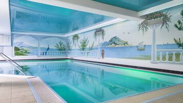 Een binnenzwembad, een buitenzwembad en parasols bij het zwembad