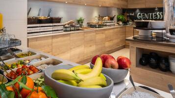 Ein Buffet mit verschiedenen Früchten und Gemüsesorten, darunter Bananen, Äpfel und Orangen.