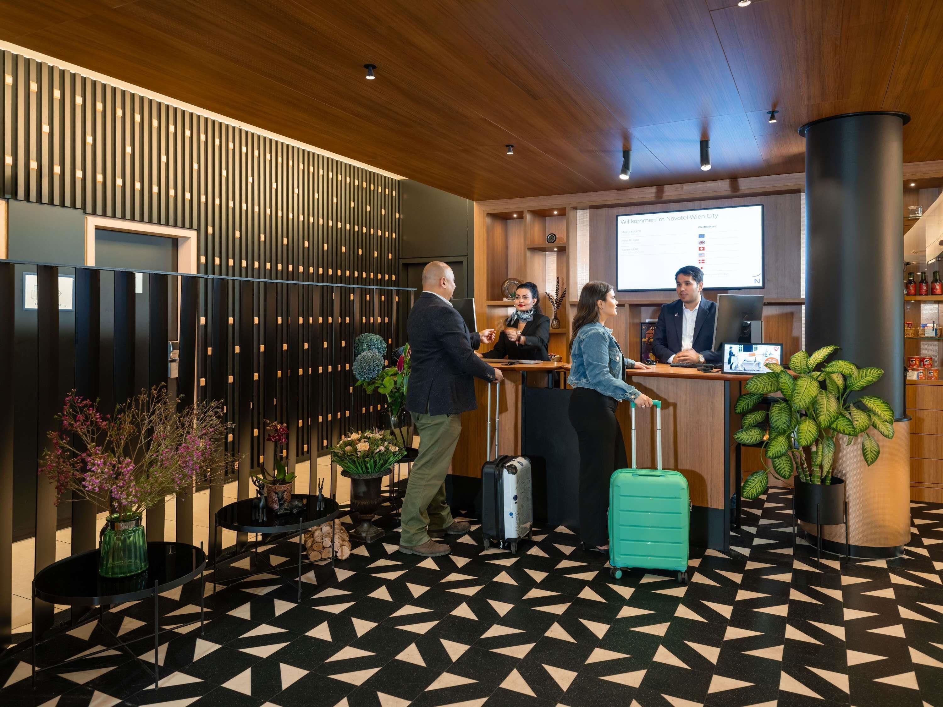 A reception area with a check-in counter, a wooden ceiling, and a patterned floor.