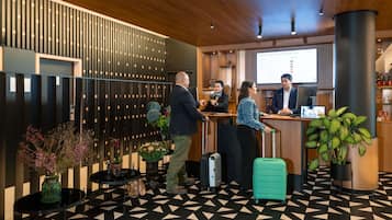 A reception area with a check-in counter, a wooden ceiling, and a patterned floor.