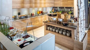 Una cocina moderna con armarios de madera, una zona de bufé con diferentes alimentos y un letrero que dice "GENIESSEK".