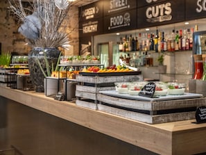 Un área de bufé con diversas opciones de comida y una selección de bebidas.