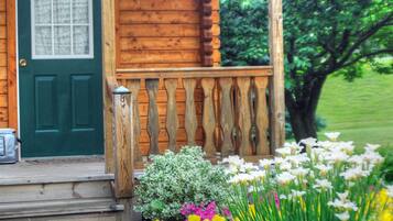 A wooden cabin with a green door, a porch with a railing, and a sign that reads "Casa Verde."