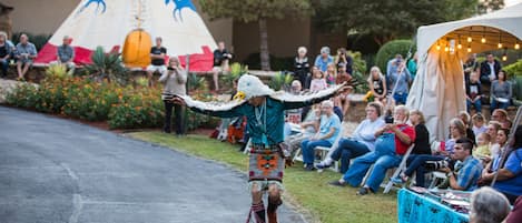 A person in traditional attire walking down a street with an audience watching.