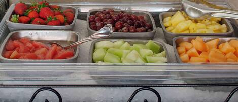 Un bufé con diversas frutas y verduras.