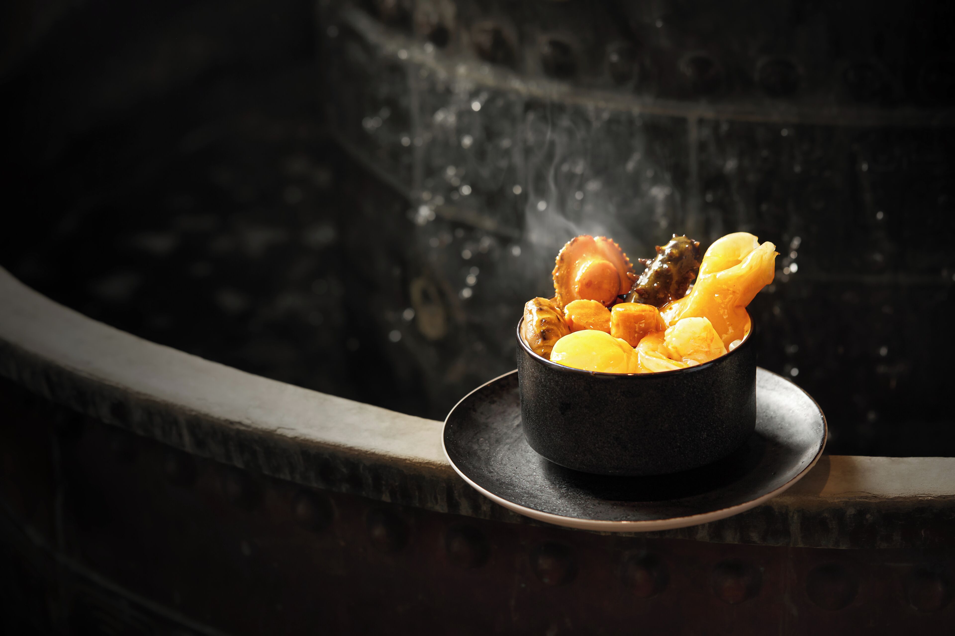 Un bol de nourriture sur une assiette, près d’un élément décoratif aquatique.