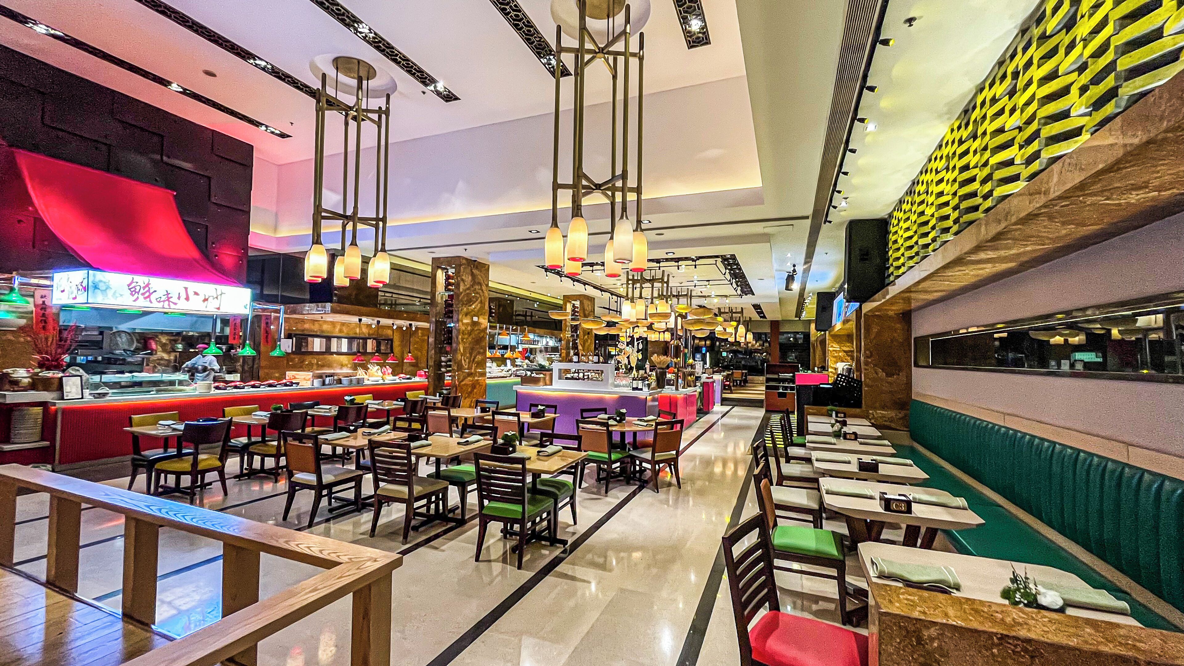 Un restaurante espacioso con varias zonas de comedor, un bar y diversas opciones de asientos, incluyendo mesas y cabinas.