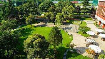 A courtyard with a central lawn, stone pathways, and outdoor seating areas.