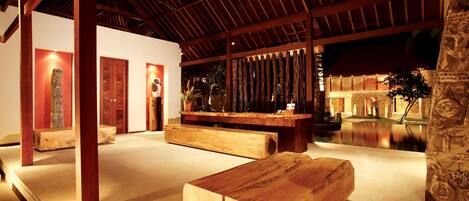 A spacious indoor area with wooden beams and a stone pillar.