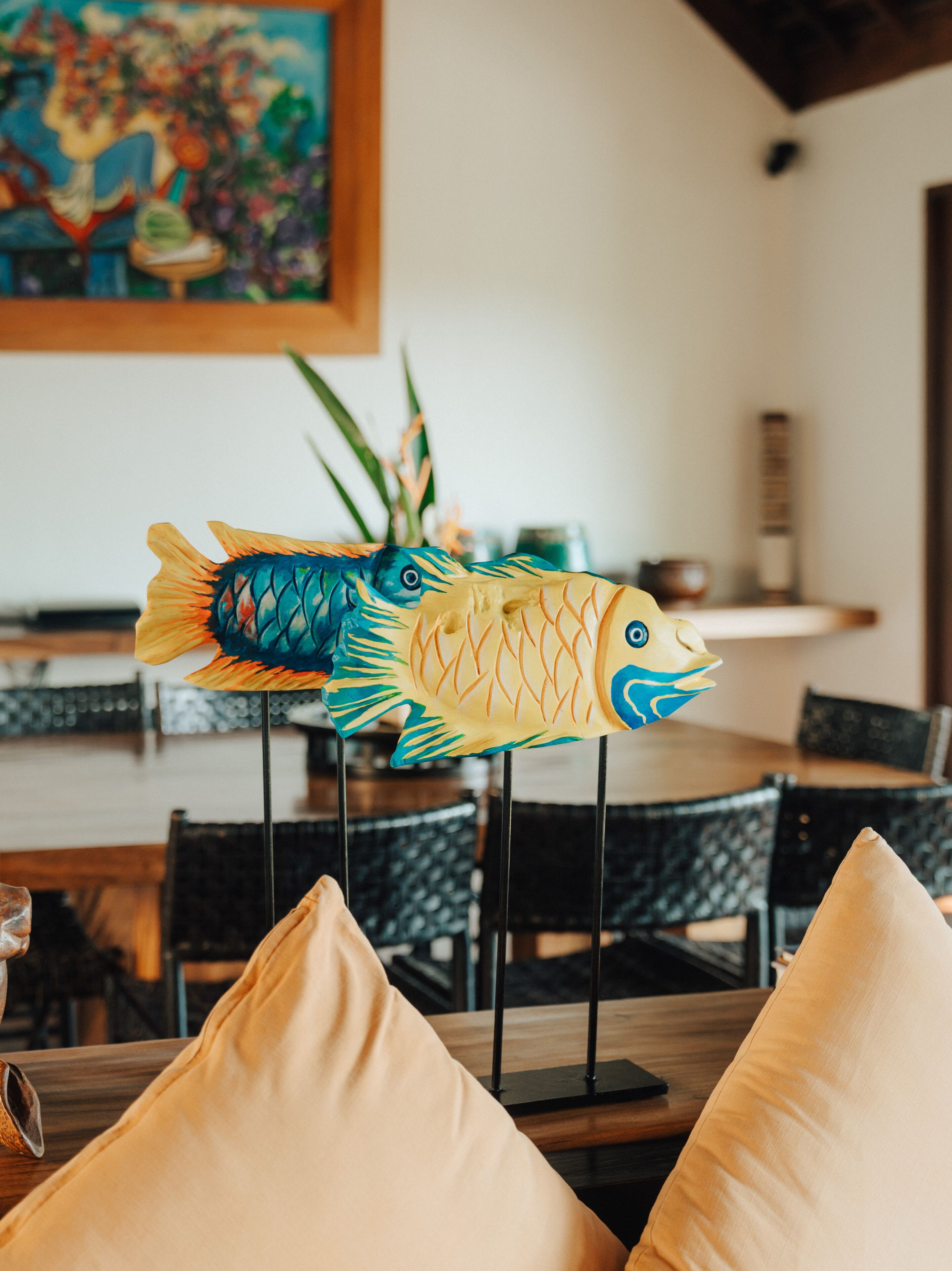 A dining area with a wooden table, black chairs, and a decorative fish sculpture.