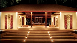 A building with a covered entrance, steps leading up to it, and decorative panels on the walls. - Qunci Villas Resort (Senggigi)