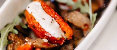 Primer plano de un plato con tomates cherry, mozzarella y hojas verdes.