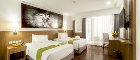 A hotel room with two beds, a desk, a TV, and a large painting on the wall.