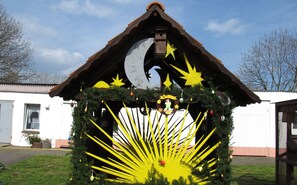 A nativity scene with a crescent moon, stars, and a star above the roof.