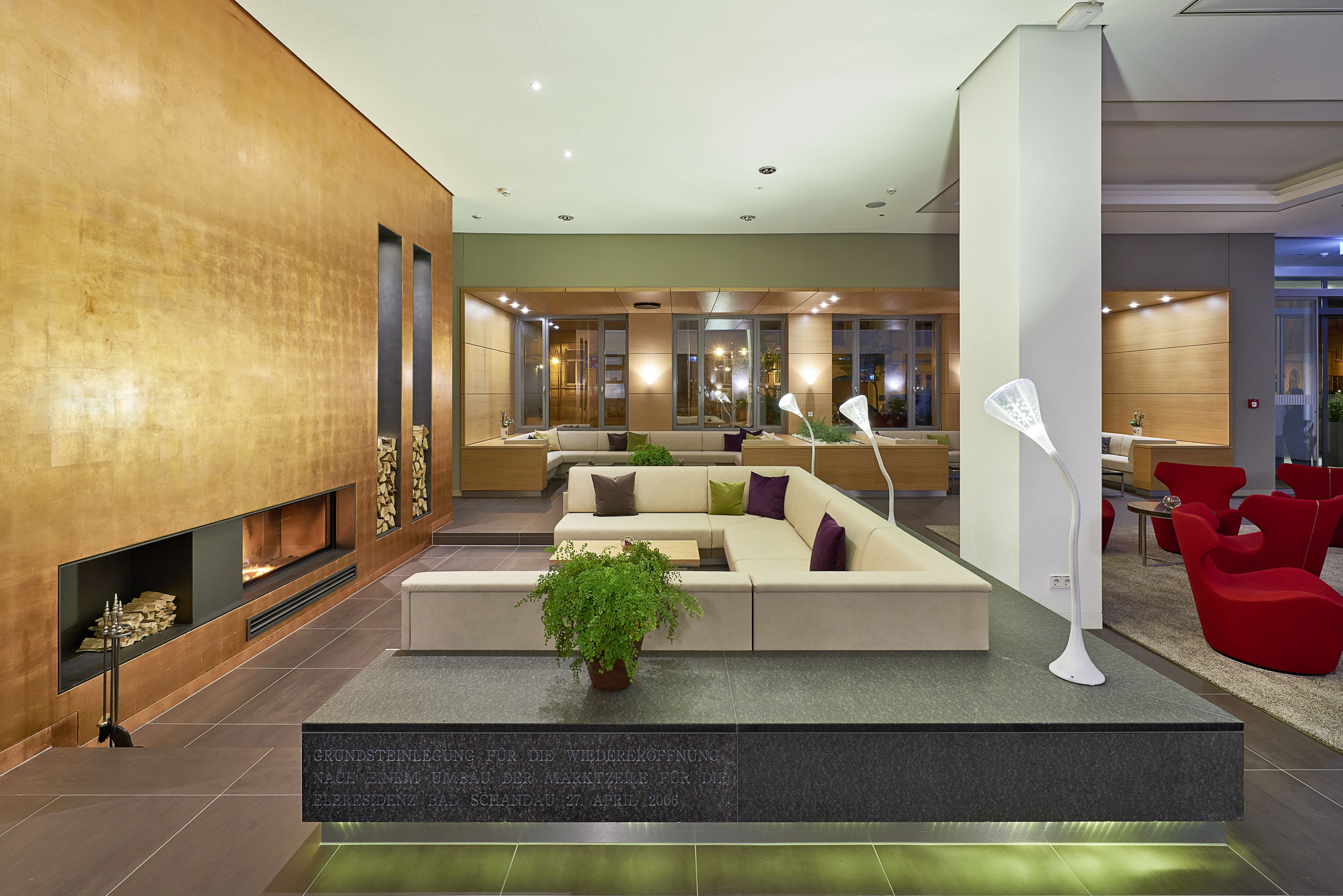 A modern lobby with a fireplace, seating area, and a reception desk.