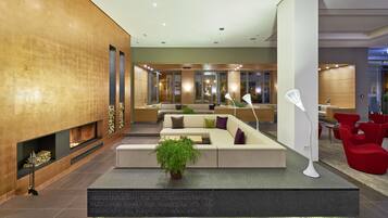 A modern lobby with a fireplace, seating area, and a reception desk.