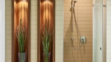 Ein modernes Badezimmer mit zwei Wandwaschbecken, einer Duschkabine und einer Glasduschtür.