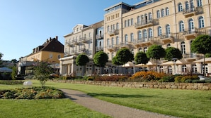 A multi-story hotel with balconies, a well-maintained garden, and a clear sky. - Hotel Elbresidenz an der Therme Bad Schandau (Bad Schandau)