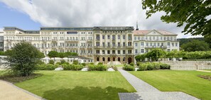 A large, historic building with multiple balconies and a central entrance.