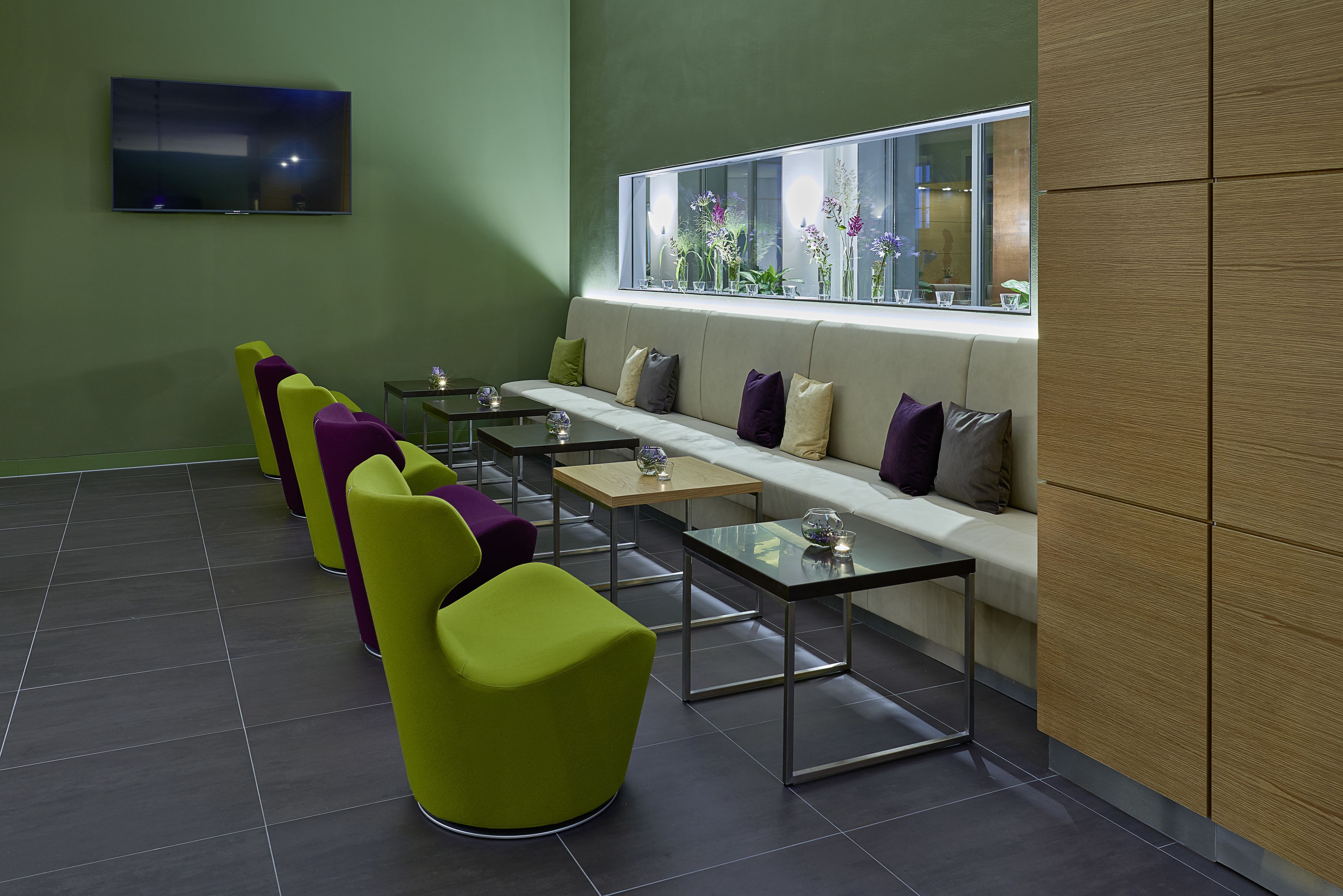 A modern waiting area with a sofa, chairs, and tables.