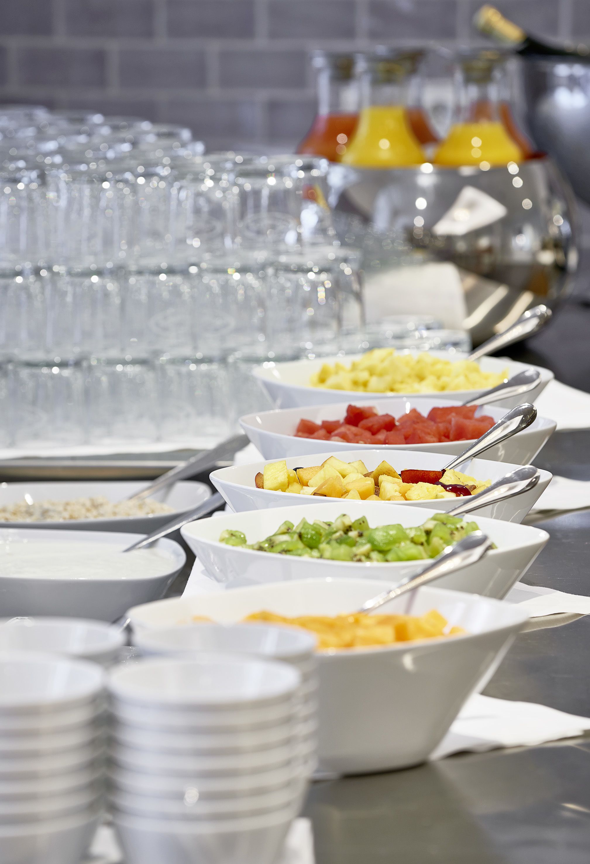 A buffet with various food items and clear glassware.