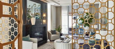 A modern living room with a fireplace, sofas, a coffee table, and a decorative partition.