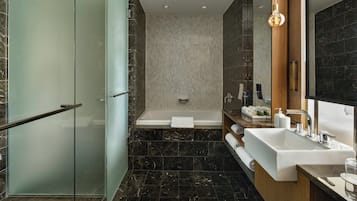 Ein modernes Badezimmer mit Duschkabine aus Glas, einer freistehenden Badewanne und einem Waschtisch mit großem Spiegel.