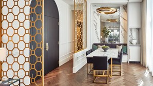 A modern dining area with a marble table, black chairs, and a geometric patterned partition. - Loden Hotel (Vancouver)