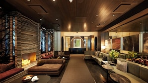 A modern lobby with a fireplace, sofas, and a coffee table. - Loden Hotel (Vancouver)