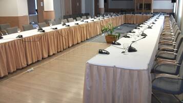 A conference room with a long table, chairs, and a podium.