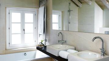 Un baño con dos lavamanos, un espejo grande y una bañera.