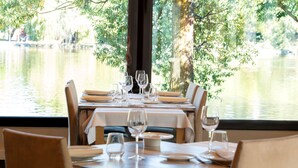 A dining table set for six with a view of a lake.