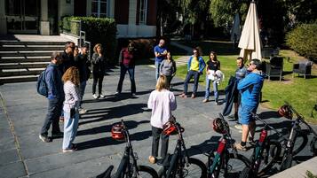 A group of people standing on a paved area with bicycles parked nearby.