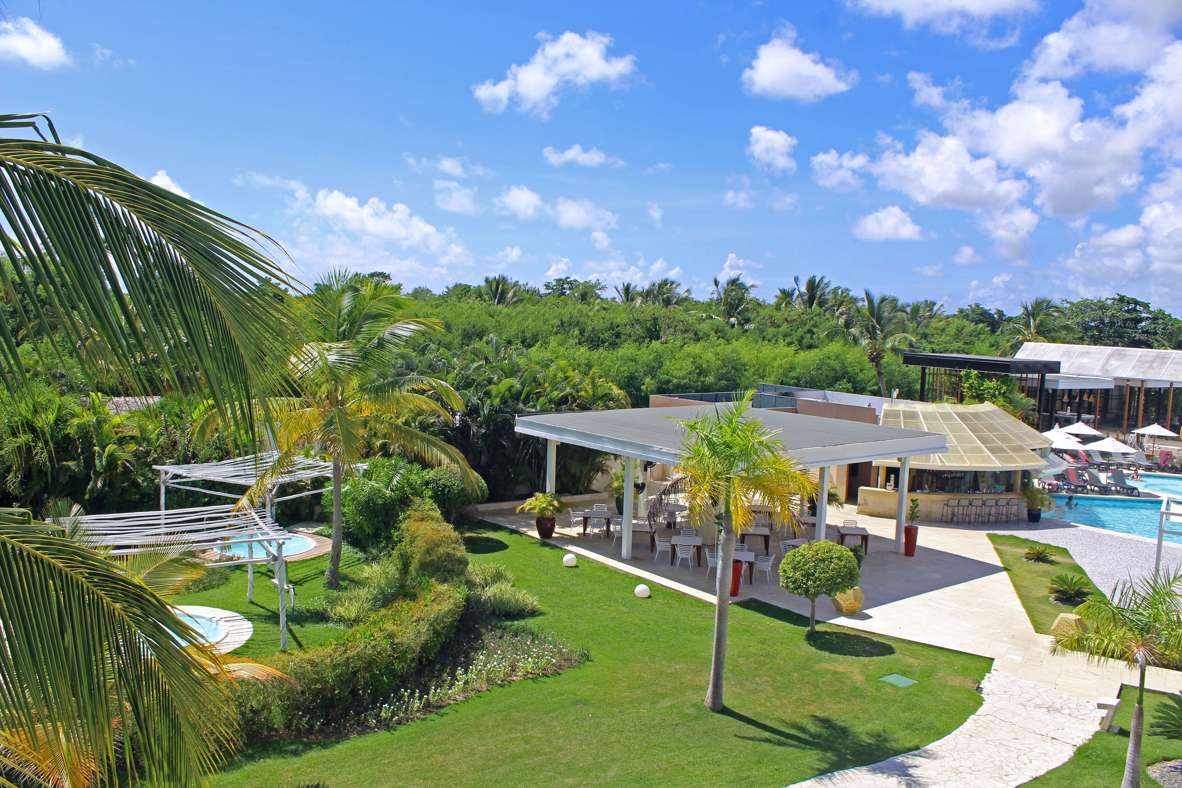 Un resort con piscina, zona de estar al aire libre y exuberante vegetación.
