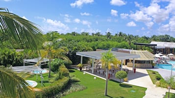 Un resort con piscina, zona de estar al aire libre y exuberante vegetación.