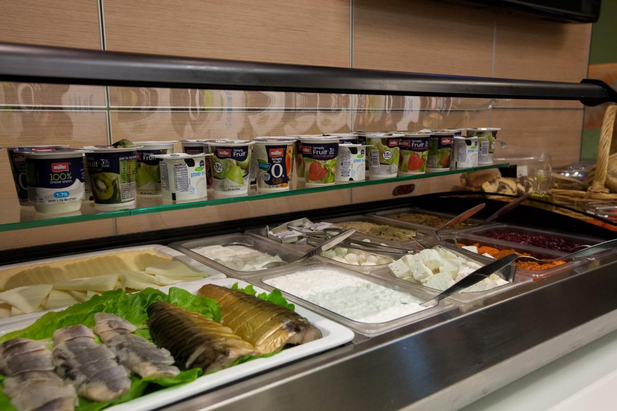 Un buffet proposant une variété d’aliments, notamment du yaourt, du fromage et du poisson.