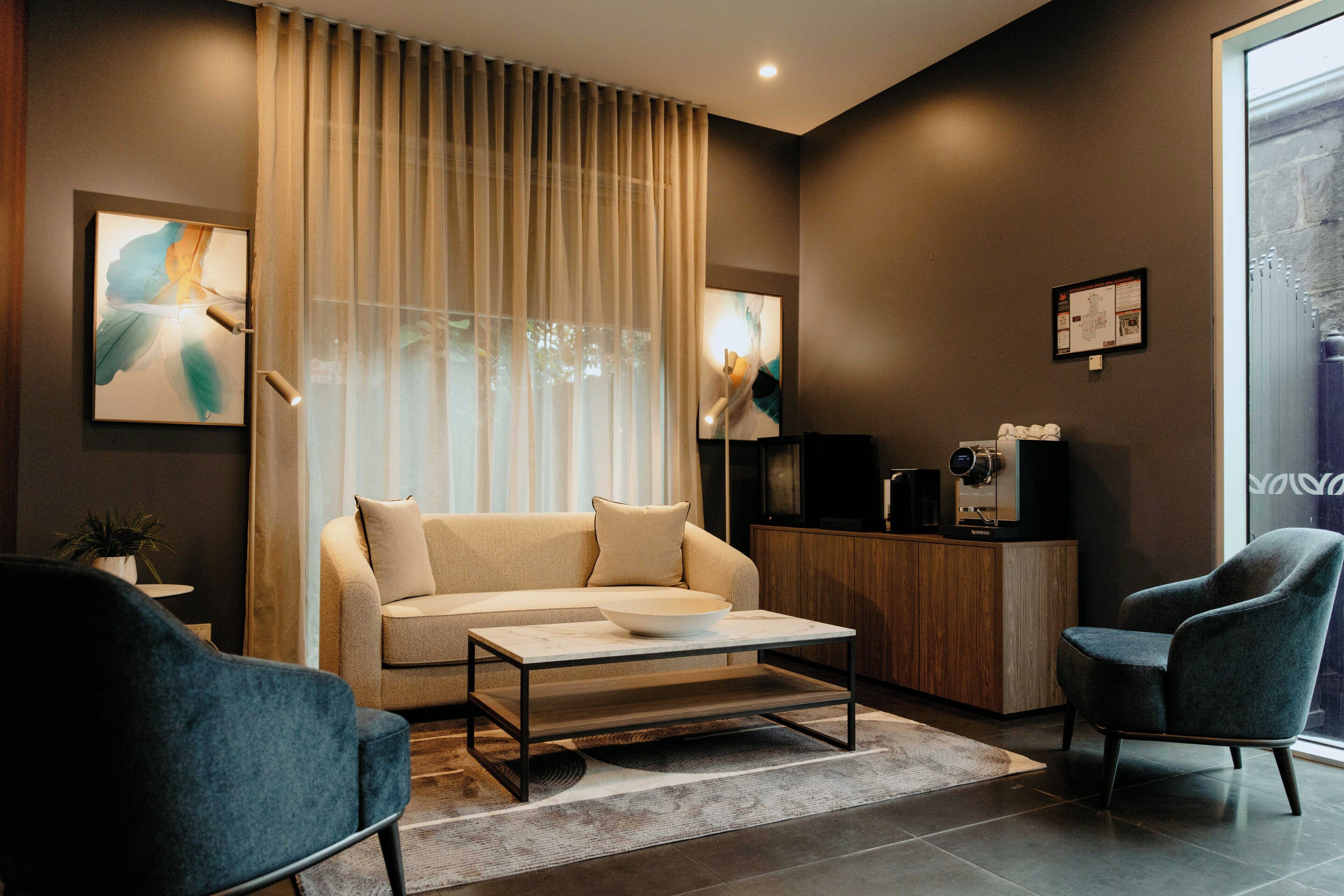 A modern living room with a sofa, coffee table, and two armchairs.